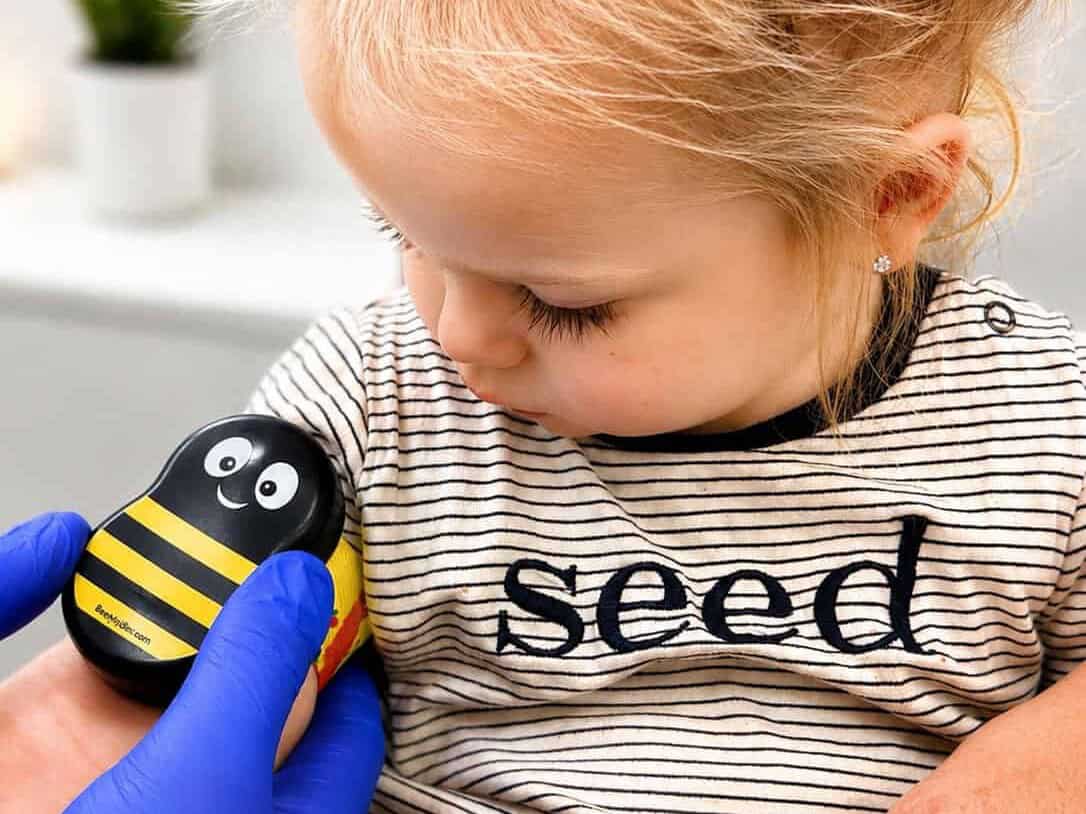Toddler comforted with a bumble bee Buzzy device before a blood test at the BRAVE Clinic, Shire Family Medical, Sutherland